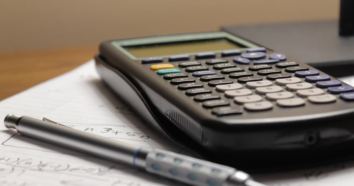 a calculator and a pen sitting on top of a piece of paper